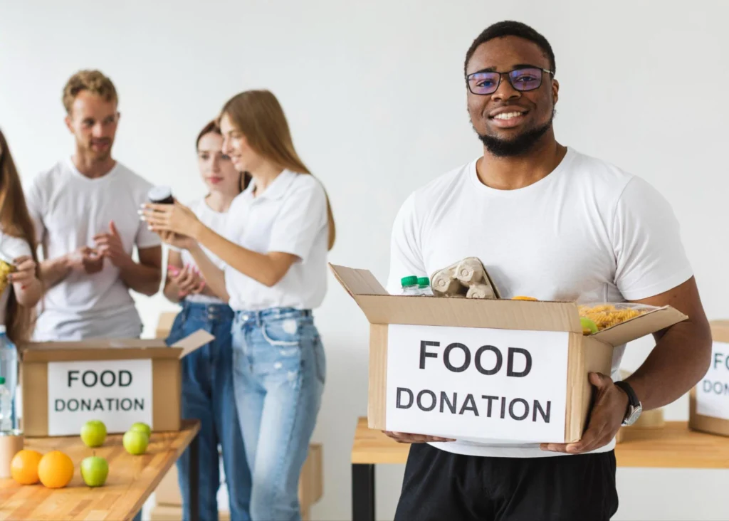 Team of volunteers sorting food donations in boxes at community food drive event