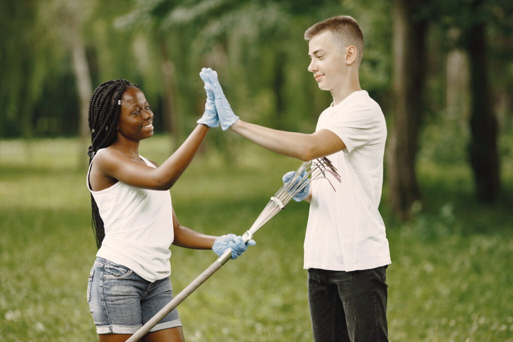 two people giving each other a high five with rubber gloves at a volunteering event