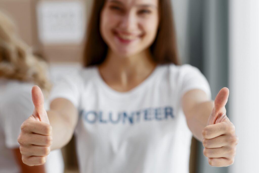 A volunteer giving two thumbs up to the camera.