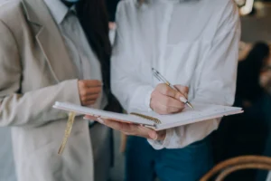 Two people debating while looking at a notebook.